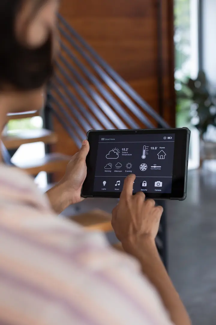 Hand bedient die Smart-Home-Steuerung auf einem Tablet
