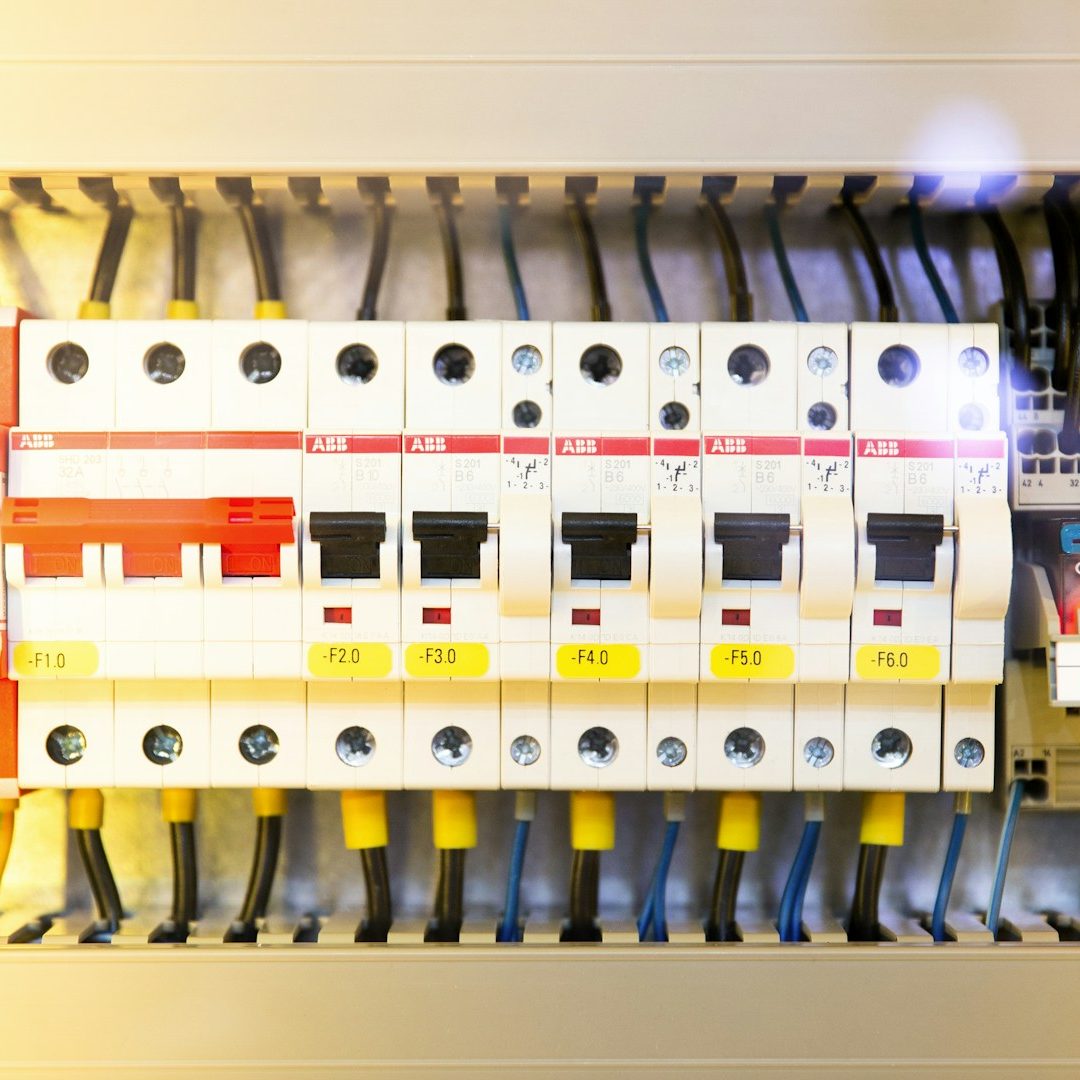 Sicherungskasten mit mehreren Schaltern und Anschlusskabeln.